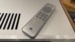 JBL SA550 integrated amplifier remote control handset sitting on top of amplifier