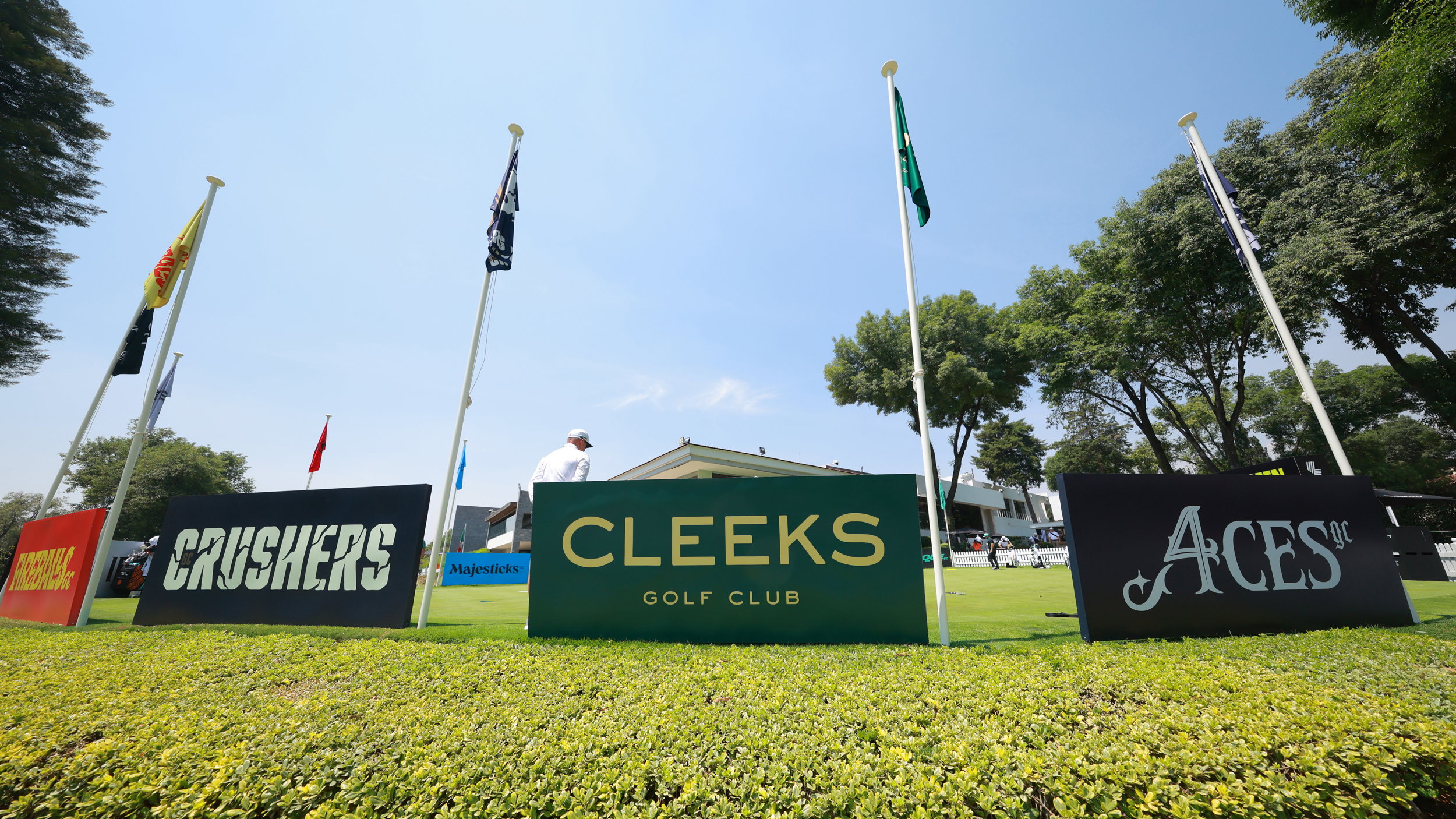 Boards on a putting green showing Crushers GC, Cleeks Golf Club and 4Aces GC logos