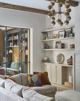 living room with off white and brown furnishings and colorful cushions