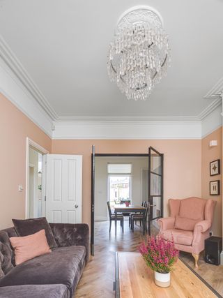 pink living room in renovated victorian house with glass internal doors