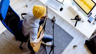 Man records an acoustic guitar vlog in his studio