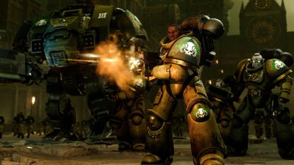A space marine in green armor firing his rifle forwards as another space marine and a dreadnought approach from behind