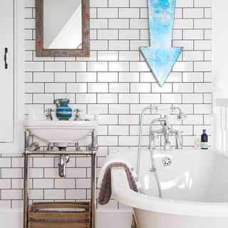 bathroom with blue retro arrow on white wall and bathtub