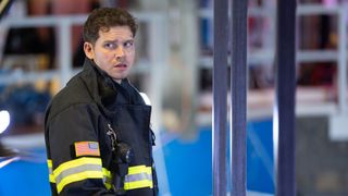 Oliver Stark as Buck looking concerned in his firefighter jacket in Season 10 of ABC's 9-1-1