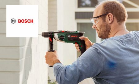 Man using Bosch drill machine to remove tiles