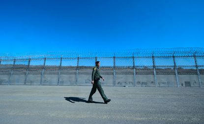 Customs and Border Protection agent Tekae Michael walks inside the Border Infrastructure System which separates the U.S. from Mexico with a fence on April 17, 2018 in San Diego, California 