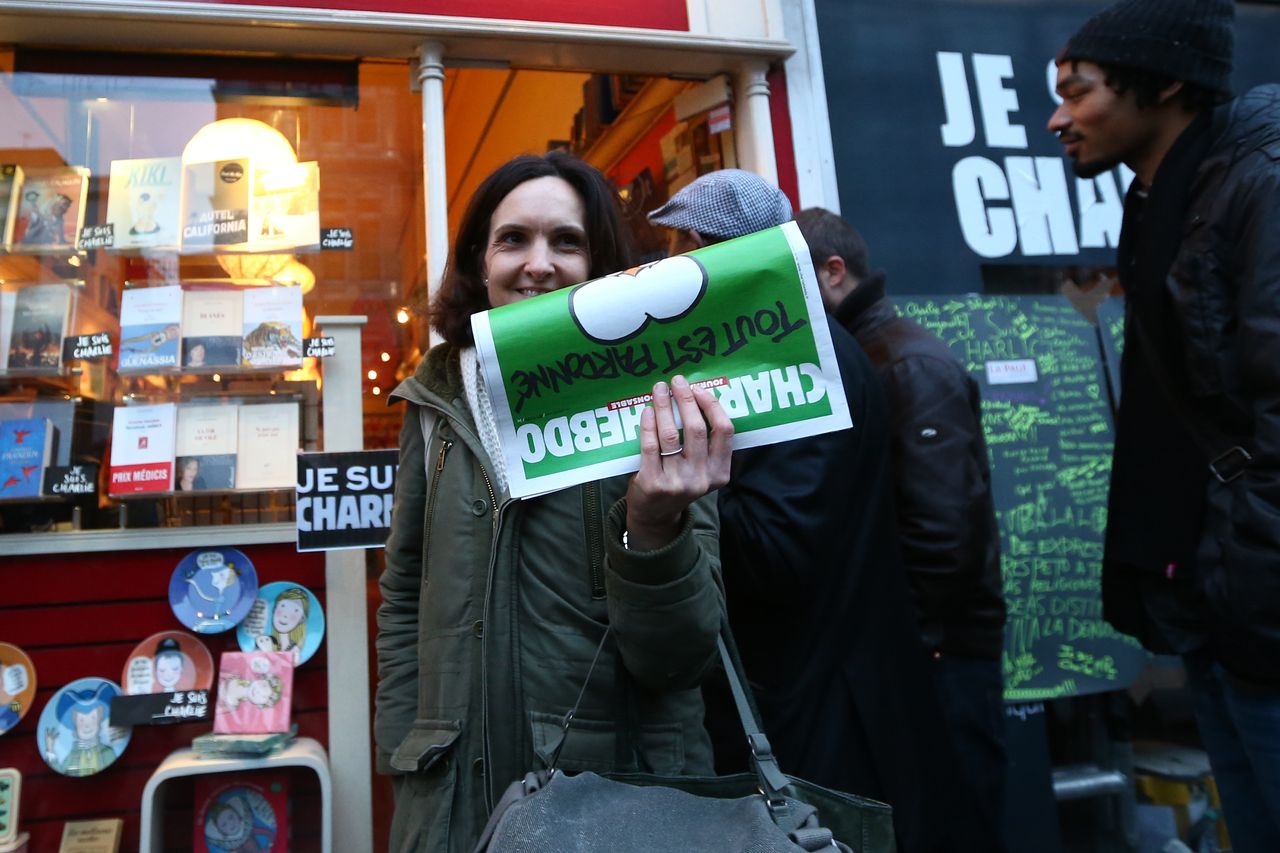 A woman holding the &amp;quot;survivor&amp;#039;s edition&amp;quot; of Charlie Hebdo