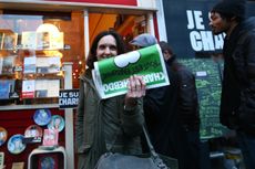 A woman holding the "survivor's edition" of Charlie Hebdo