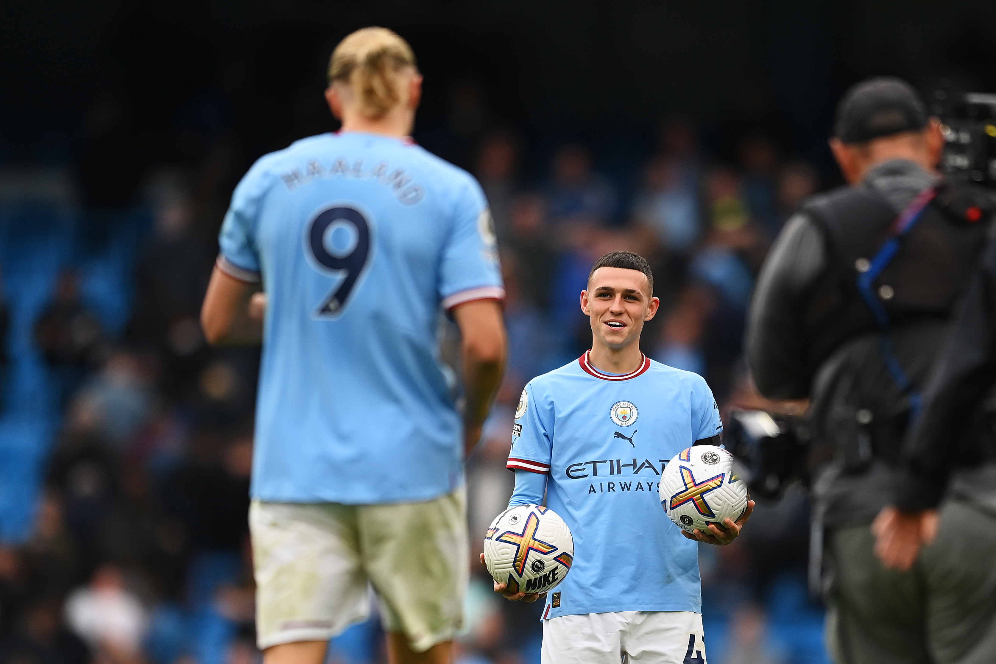 Phil Foden hands a match ball to Manchester City team-mate Erling Haaland after both players scored a hat-trick in a 6-3 win over Manchester United in October 2022.