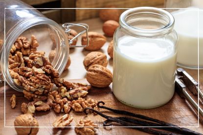 Dairy-free milk and walnuts on a wooden surface