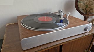 Victrola Stream Sapphire turntable, with light-up knob, on a wooden table