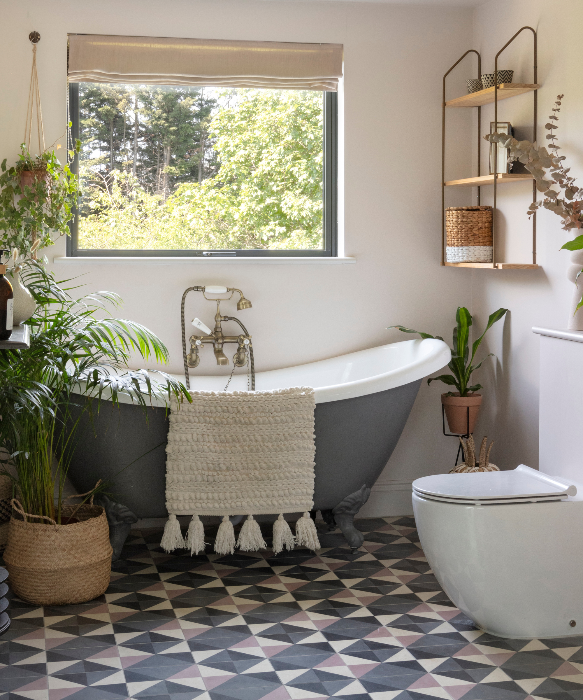 bathroom with patterned flooring and grey freestanding bath