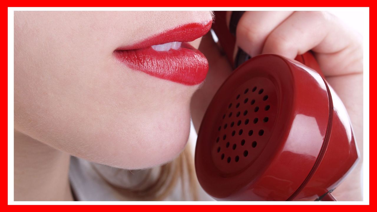 Macro of red phone and woman&#039;s mouth; white background; how to have phone sex