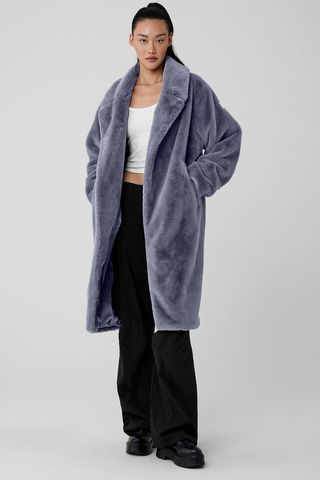 Oversized Faux Fur Trench - Fog by Alo Yoga on a model in front of a plain backdrop