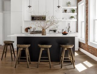A kitchen with white cabinets and dark wood floor