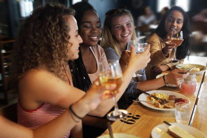 Woman drinking in a restaurant together as lockdown rules are changing from May 17