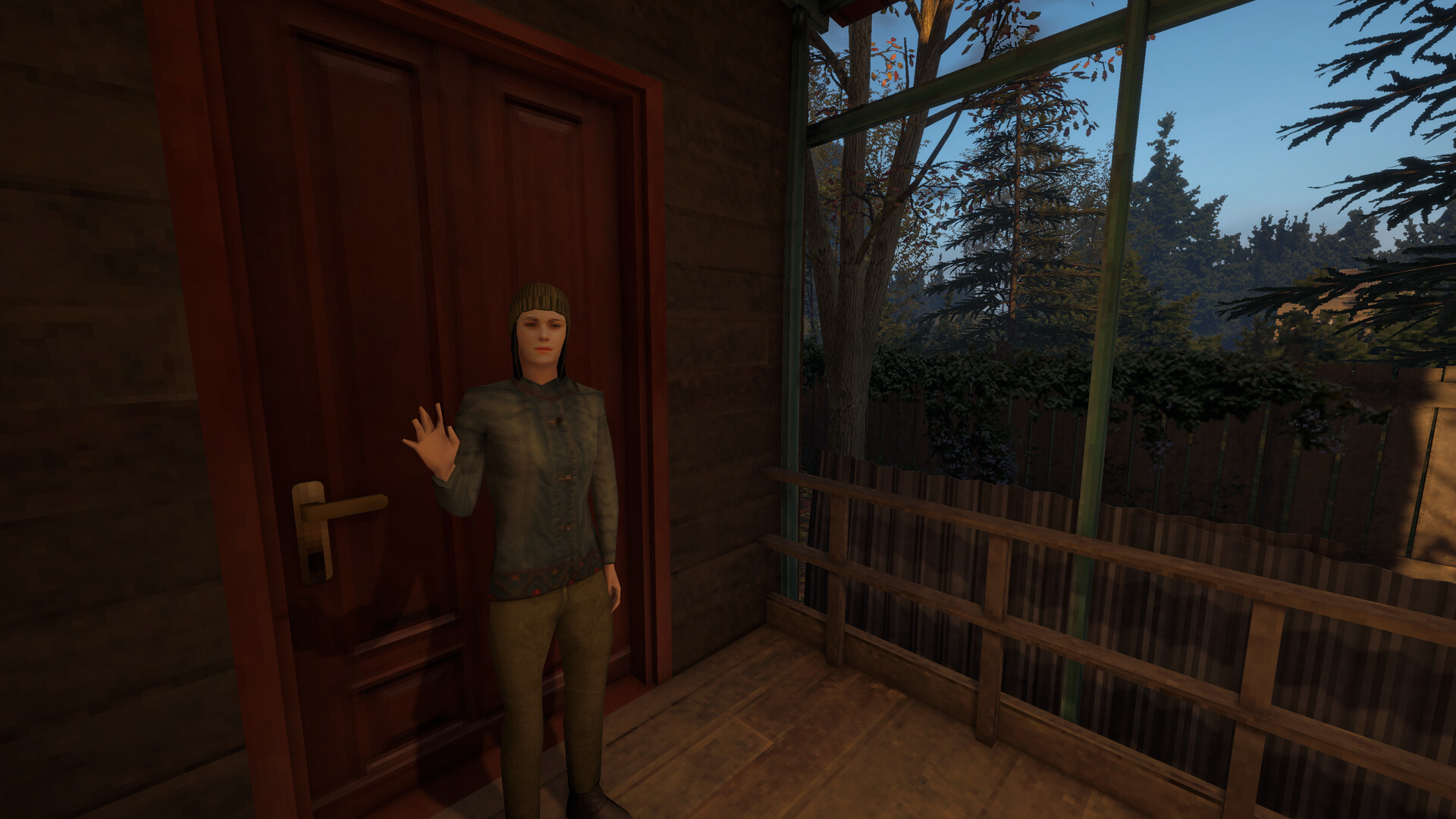 A woman stands in front of a door, waving