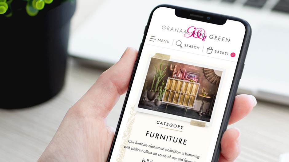 Hand holding phone showing Graham & Green website