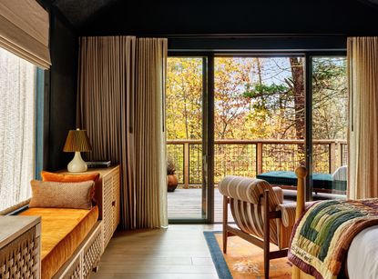 A bedroom with a view and a colorful quilt