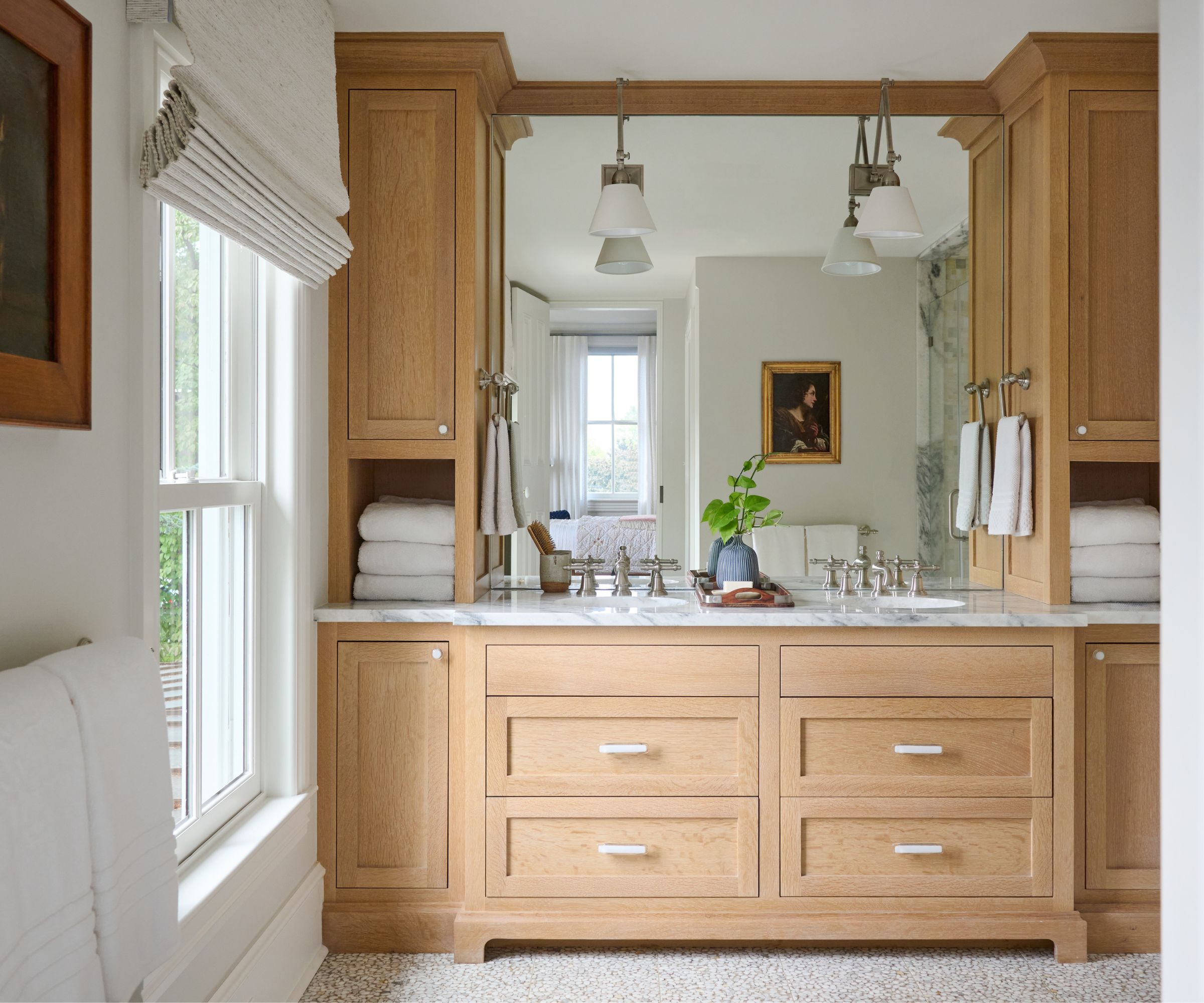 A white bathroom with a wooden bathroom vanity and surrounding storage units