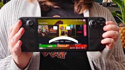 Phil Hayton holding Steam Deck with sad text face on screen.