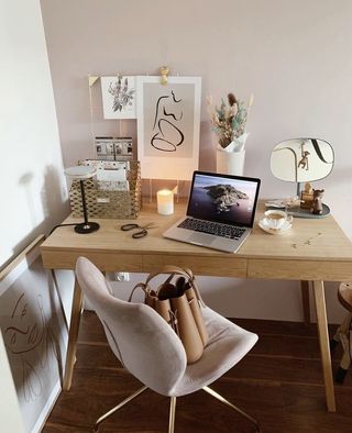 Wooden desk with pink chair and wall art