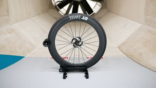 A front DT Swiss ARC 1100 wheel sits in front of the fan within a wind tunnel