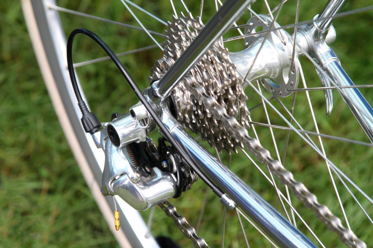 A polished rear derailleur mech and cassette on a vintage looking bicycle