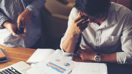 A stressed employee looking over some graphs