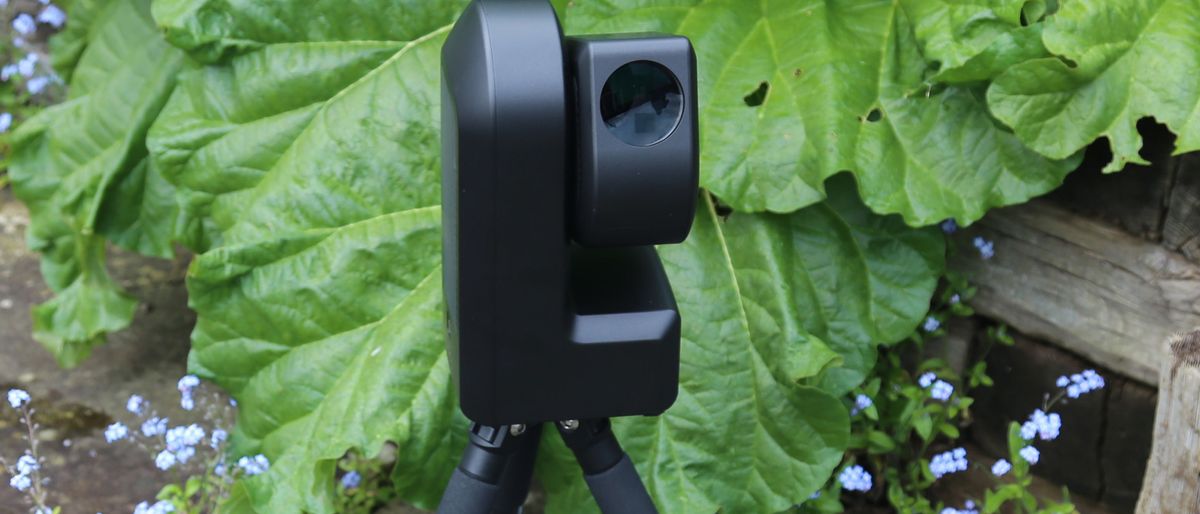 ZWO SeeStar S50 smart telescope against green foliage