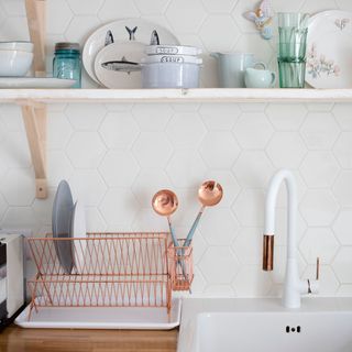 kitchen with white hexagon design wall white shelf and wash basin