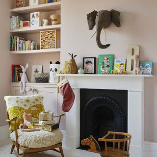 room with shelves on wall grey fireplace and wooden chair