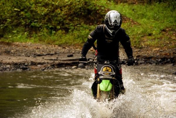 The lead moto crosses a stream
