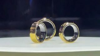 Three gold Samsung Galaxy Rings glimmering in a display case