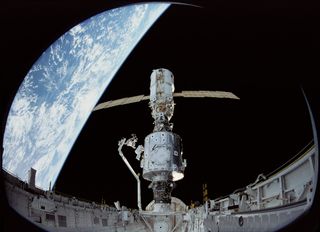 In December 1998, the crew of Space Shuttle Mission STS-88 began construction of the International Space Station, joining the U.S.-built Unity node to the Russian-built Zarya module. Astronaut James Newman works on communication cables on Unity while Astr