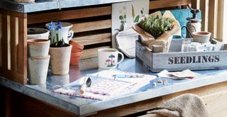 A zinc potting bench with gardening tools