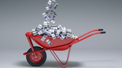 British money being emptied into wheelbarrow