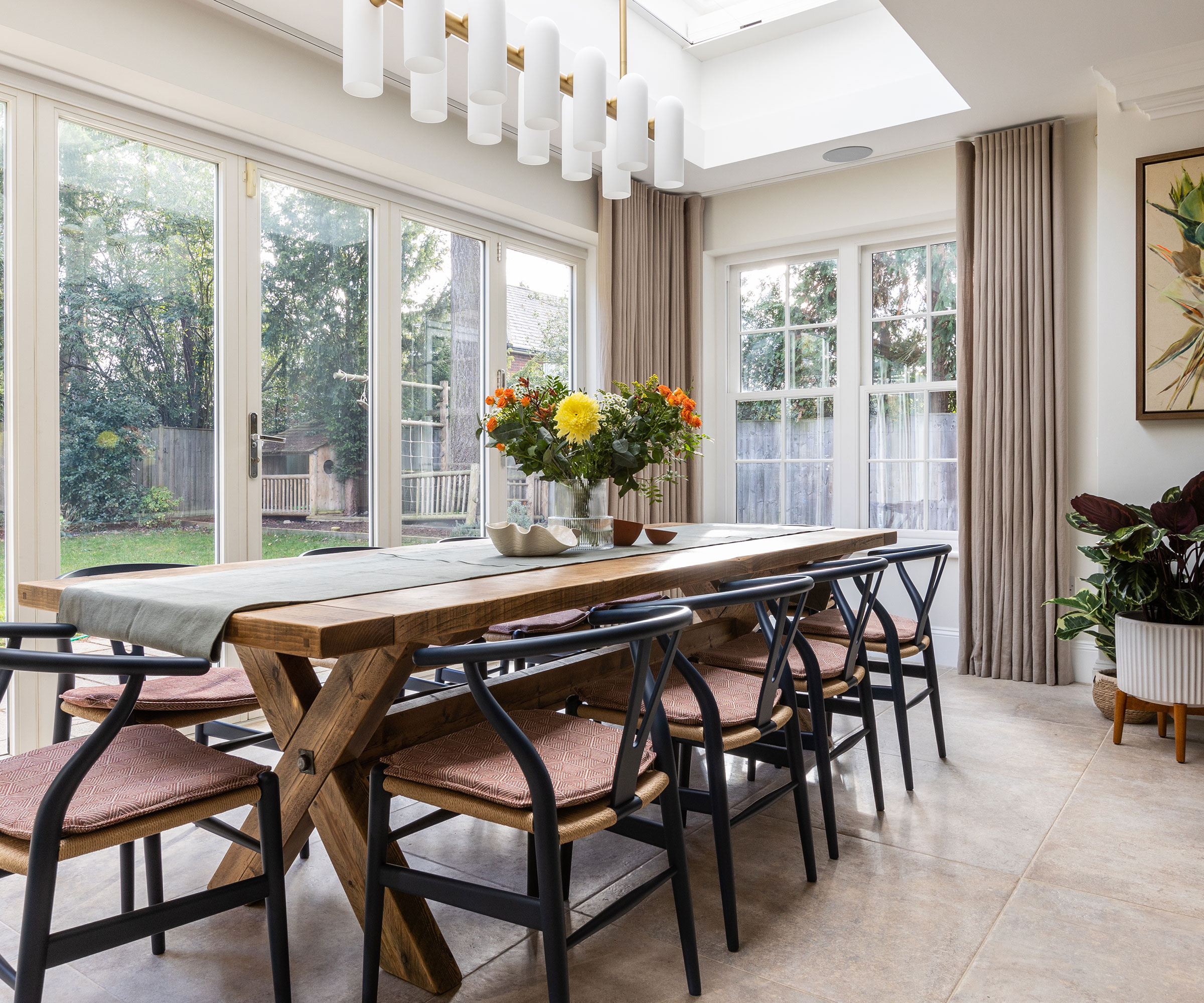 orangery style dining room with wooden dining table and large format floor tiles