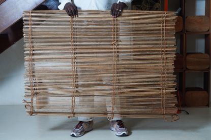 A man holding a woven screen.