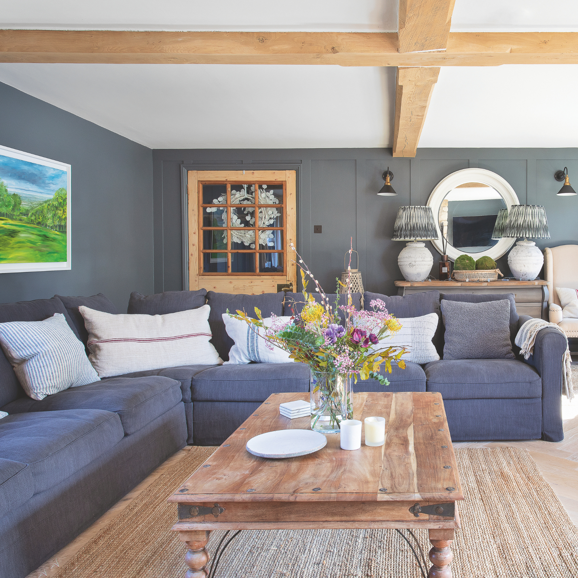 Navy living room with white ceiling and exposed beams.