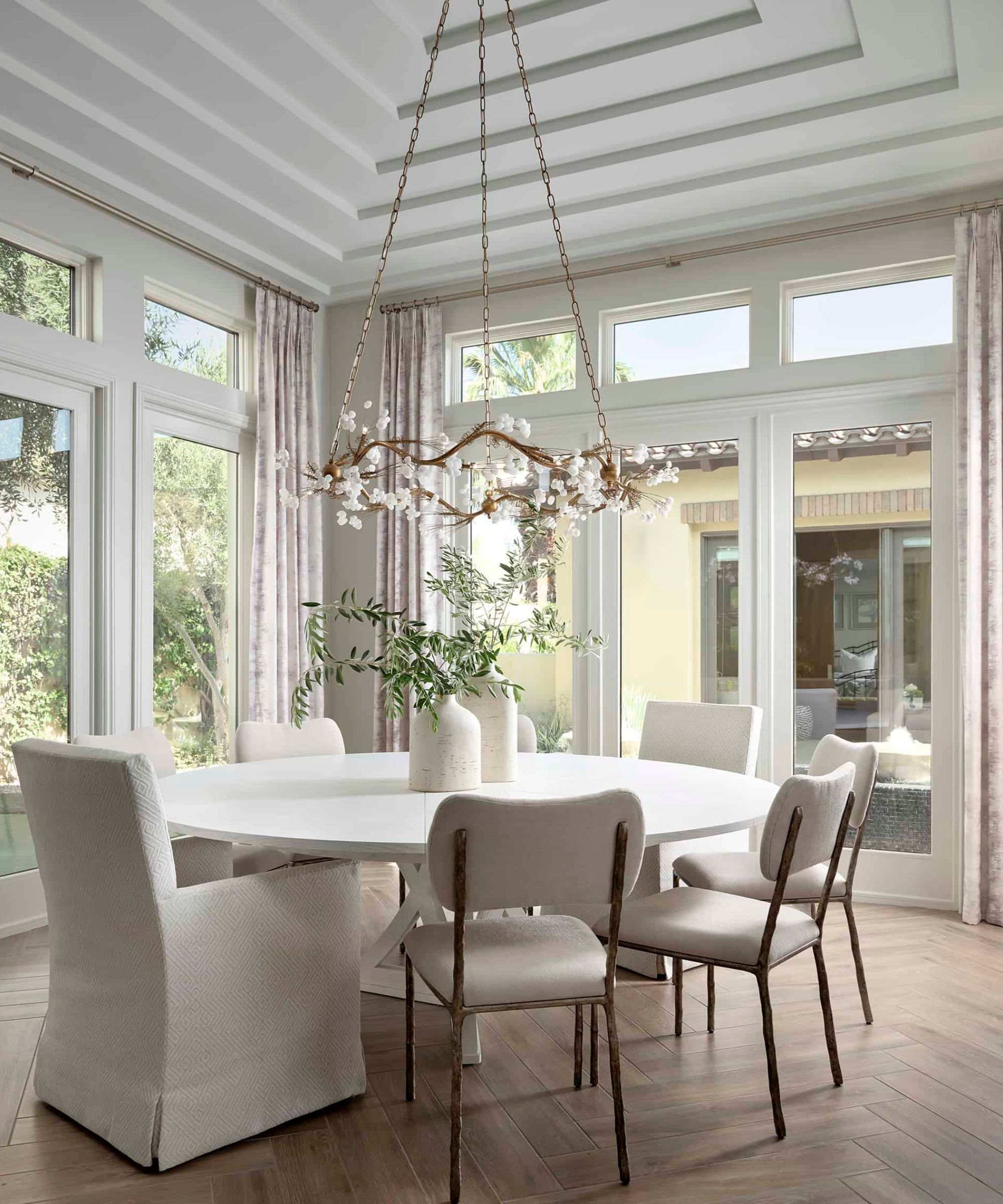 A neutral dining room with a round white table at the center