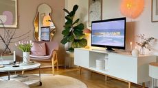 Living room with white rug, TV, and stand