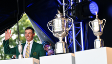 Rory McIlroy poses next to his Major trophies