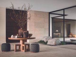 Open plan entryway brings in elements of the outdoors in the stone feature, and glass walls allow each room to flow between each another