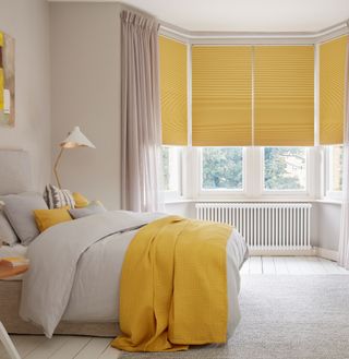 bedroom with white wall and yellow blinds