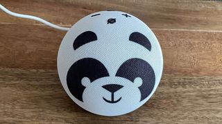 The top view of a Amazon Echo Dot Kids smart speaker on a wooden table with a patterned background