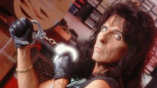 Alice Cooper holding a pair of handcuffs