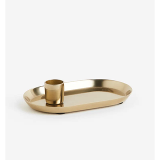 gold tapered candle holder with a tray attached