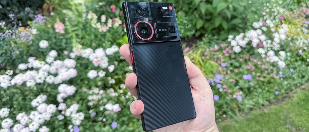 Person holding the Nubia Z60 Ultra Leading Version in front of a flowerbed