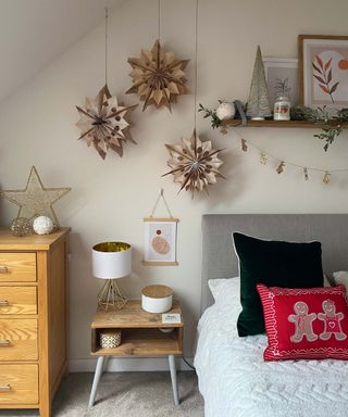 homemade christmas star decorations made from paper bags hanging in a bedroom with festive decor